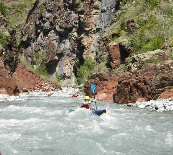 Descente sportive en kayak monoplace au milieu des roches rouges d'un canyon d'eau vive, les Gorges de Daluis