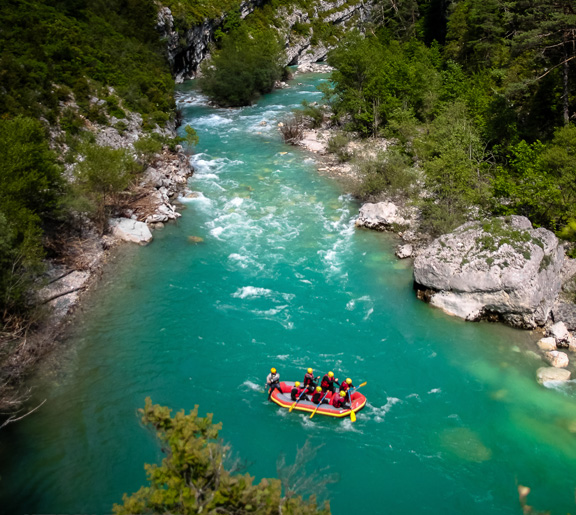 Vue plongeante sur une descente en rafting sur une rivière turquoise entourée de forêts dans les Gorges du Verdon proche de Castellane
